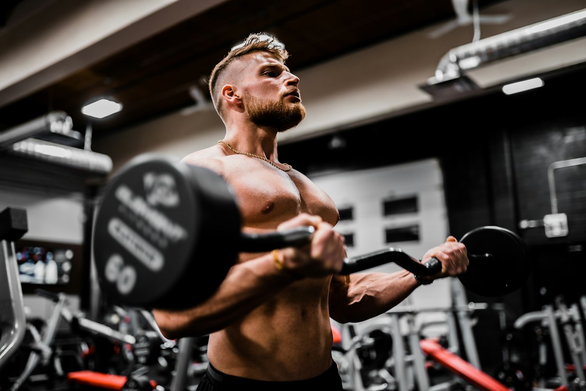 Lifter gripping barbell on flat bench press station in gym free weights zone